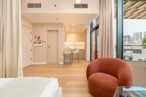 ein Schlafzimmer mit einem Bett und einem Stuhl in der Unterkunft Upgraded Designer-crafted Studio in JVC with Massive Terrace in Dubai + 17 Fotos