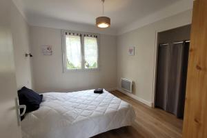 a bedroom with a white bed and a window at BEL appartement T5 NEUF avec 4 chambres in Tarbes