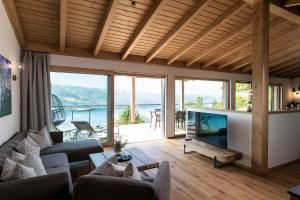uma sala de estar com um sofá e uma televisão com vista em Chalet Seeblick em Millstatt