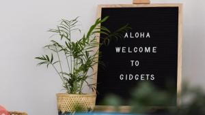 a plant sitting next to a sign with a welcome to gibbers at Gidgets on Gretel in Nelson Bay +18 photos