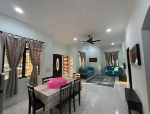 a living room with a table and a ceiling fan at Faris's Homestay & Resort in Pasir Puteh