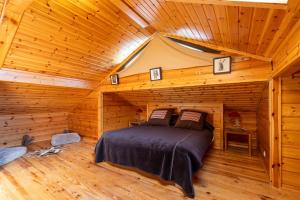 una camera da letto in una baita di tronchi con un letto in esso di Chalet des Jonquilles - Magnifique maison avec piscine a Les Angles Altre 24 foto