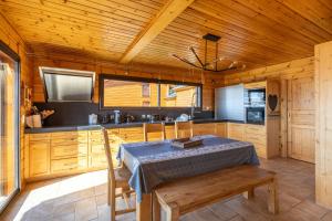 una cucina con mobili in legno, tavolo e sedie di Chalet des Jonquilles - Magnifique maison avec piscine a Les Angles