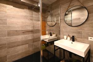 a bathroom with two sinks and a mirror at Mirador montagnard - Appt vue montagne in Soultzeren