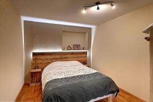 a bedroom with a bed with a wooden headboard at Mirador montagnard - Appt vue montagne in Soultzeren