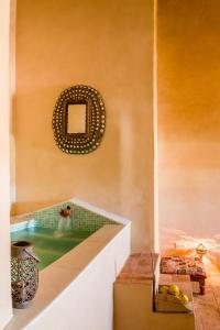 y baño con bañera y espejo en la pared. en Balneario Aguas de Villaharta, en Villaharta