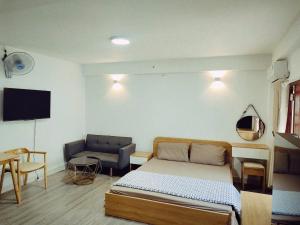 Un dormitorio con una cama, un sofá y un televisor. en Rose House 302, en Ho Chi Minh