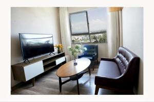 a living room with a television and two chairs and a table at N's house in Phan Thiet