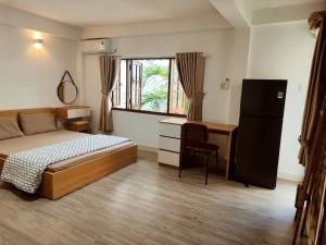 Un dormitorio con una cama y un escritorio y una ventana. en Rose House 302, en Ho Chi Minh 3 fotos más