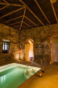 - une piscine dans un bâtiment en pierre avec une piscine dans l'établissement Balneario Aguas de Villaharta, à Villaharta
