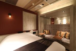 新潟市にあるHOTEL Us Bentenbashi Adult onlyのベッドとベンチのある寝室