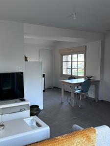 een woonkamer met een bank en een tafel met een tv bij Gîte de Villedavid in Amboise