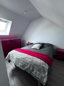 een slaapkamer met een bed met een rode deken bij Gîte de Villedavid in Amboise