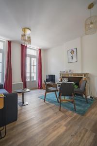 a living room with red curtains and a table and chairs at Le balcon du roi René in Avignon