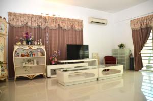a living room with a tv and a white furniture at Near Gurney 3-Storey Event Hse by Felice Homestay in Tanjong Tokong