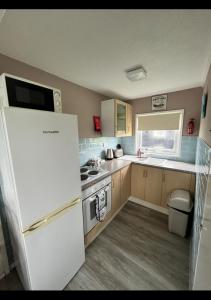 a kitchen with a white refrigerator and a stove at California Beach Chalet in Great Yarmouth +4 photos