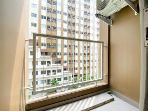 a window with a view of a tall building at Great Choice Studio Apartment Gateway Park LRT City Jatibening By Travelio in Bekasi