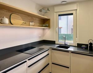 a kitchen with a sink and a window at Azul Andrin in Andrín
