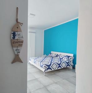 a bedroom with a bed and a blue wall at Perla blu Salento in Gallipoli