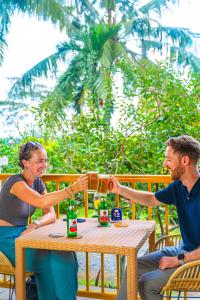 a man and woman sitting at a table with drinks at Hotel Deli River and Restaurant Omlandia in Medan