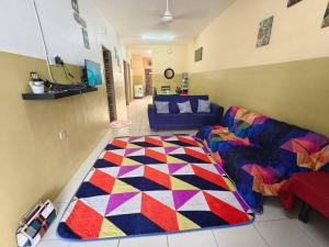 a living room with a couch and a colorful rug at Homestay BRP Bypass 69 in Kuantan