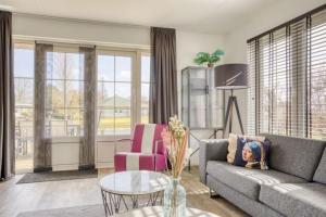 a living room with a couch and a table at Beachvilla it Langezand - Villa aan het vaarwater en vlakbij strand in Makkum