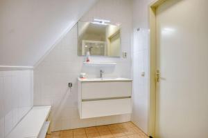 a white bathroom with a sink and a mirror at Beachvilla it Langezand - Villa aan het vaarwater en vlakbij strand in Makkum +36 photos