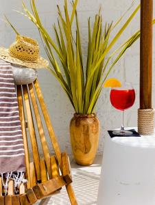 a vase with a plant and a glass of wine at PALAZZO CAVÌ in Mola di Bari