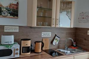 a kitchen counter with a sink and a microwave at NEU! Ferienwohnung Brandy in Bad Muskau