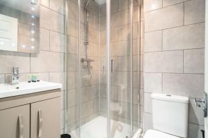 a bathroom with a shower and a toilet and a sink at Bright 2 Bed Apartment in Central Blackburn in Blackburn
