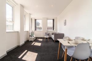 a room with white tables and chairs and windows at Bright 2 Bed Apartment in Central Blackburn in Blackburn