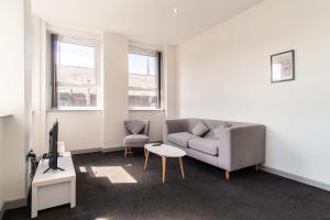 a living room with a couch and a table at Bright 2 Bed Apartment in Central Blackburn in Blackburn