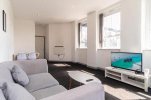 a living room with a couch and a tv at Bright 2 Bed Apartment in Central Blackburn in Blackburn