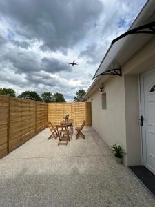 ヴィルヌーヴ・ル・ロワにあるMaison BRのテーブルと椅子のあるパティオの上を飛ぶ飛行機