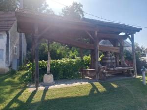 a wooden pergola with a bench in a yard at Ferienwohnung Wein-Bleibe in Großkrut