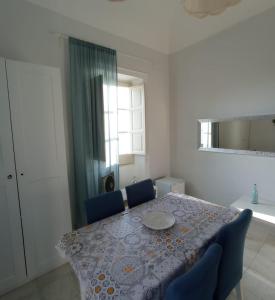 a dining room table with blue chairs and a window at Piccolo borgo antico Cefalù in Cefalù