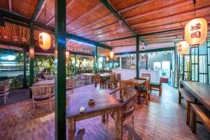 a restaurant with wooden tables and chairs and a restaurant with chinese signs at Jetian private villas in Nusa Lembongan