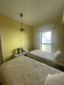 a hotel room with two beds and a window at VRS - PORTO BEACH FLAT in Porto