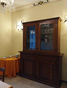 a large wooden cabinet in a room with a table at VILLINO CHELIDONIA SUBIACO in Subiaco