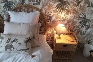 a bedroom with a bed and a night stand with a lamp at Gîte Guldangel in Hirsingue