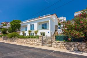 a white house with a stone wall at Amarie in Dramalj