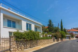a house with a stone wall and a street at Amarie in Dramalj