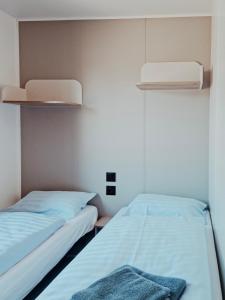 two beds in a small room with two lamps at Super Cordelia - Camping Belle-Vue in Berdorf +5 photos
