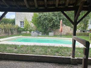 a swimming pool in a yard with an umbrella at La Maison du Chablisien in Chablis