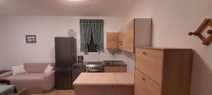 a small kitchen with a refrigerator and a couch at Vake in Herceg-Novi