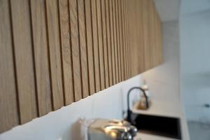 a kitchen counter with a sink and a wooden wall at SOL Baška Voda in Baška Voda +18 photos