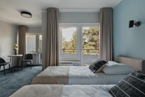 a bedroom with two beds and a window at Ośrodek Jantar Rewita in Hel