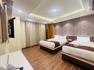 Kama o mga kama sa kuwarto sa Hotel Nirakar