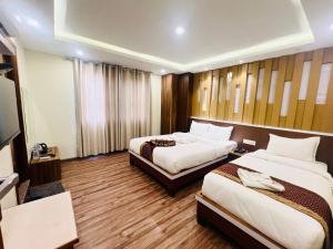 Kama o mga kama sa kuwarto sa Hotel Nirakar