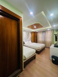 Kama o mga kama sa kuwarto sa Hotel Nirakar